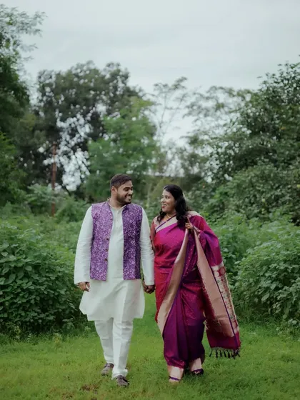 A walking shot of the couple in a beautiful green park. This type of photo feels natural and captures the couple's comfortable interaction.