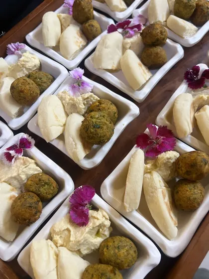 A classic party starter, our falafel and pita bites. We serve our freshly fried falafel with creamy hummus and soft mini pita bread, garnished with edible flowers for a beautiful touch.