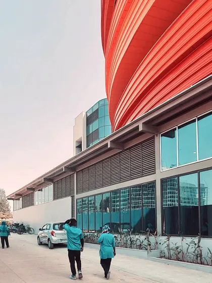 People walk along the glazed facade of the MARC building, illustrating how the structure is designed to be an active and engaged part of the campus environment.