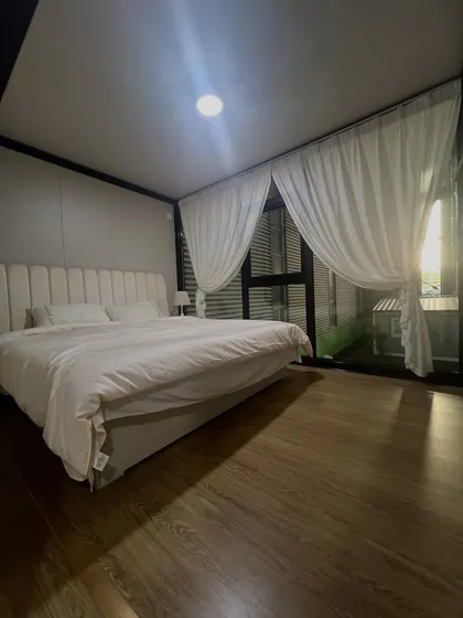 A bedroom should be a sanctuary. In this modular home interior, we've used soft lighting, clean lines, and large windows to create a peaceful and inviting space that connects you with the outdoors.