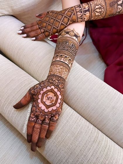 A different angle of the personalized 'NP' bridal mehandi, showing how the design on the back of the hand complements the detailed work on the arm.