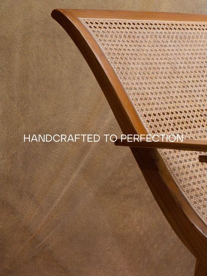 A detail of my teak wood rocking chair, showing the graceful curve of the frame and the meticulously woven rattan back. It's handcrafted for relaxation.