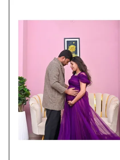 A sweet couple's portrait featuring our vibrant purple gown. The color stands out beautifully against the simple, modern pink backdrop of the studio.