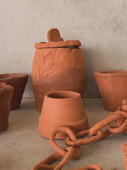 A collection of terracotta pieces, including a pot with a chain link sculpture. Students are always pushing creative boundaries.