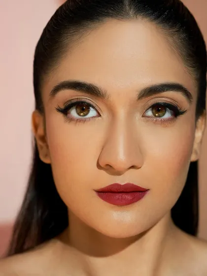 A direct, confident gaze that shows off the classic pairing of a bold red lip and a perfect winged liner. This look is eternally chic.