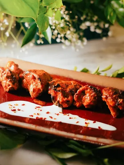The Chicken Banjara Tikka is intensely flavored and delicately plated. The chicken is marinated in a blend of rustic spices, grilled, and served with a yogurt-based sauce.