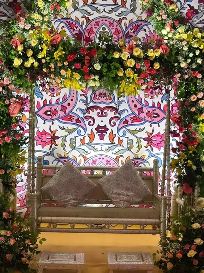 A close-up of the floral swing, showcasing the rich colors and dense flower arrangements that create a perfect photo spot for the bride.