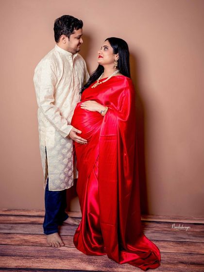 A sweet, interactive pose where the couple is looking at each other, sharing a private moment during their traditional maternity session.