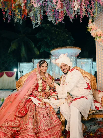 A beautiful portrait of the couple seated on a grand golden throne after their wedding ceremony, looking like royalty.