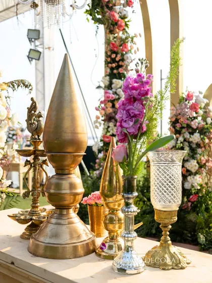 Traditional brass artifacts and fresh flowers create a beautiful and auspicious detail. These small touches help to ground the decor in heritage and add a layer of meaning to the celebration.