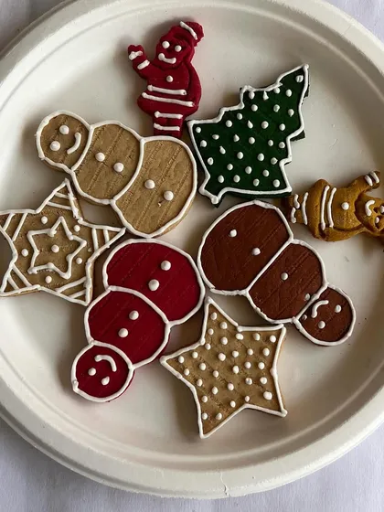 A plate of my assorted Christmas cookies for dogs. Featuring festive shapes like snowmen, trees, and stars, they are a perfect stocking stuffer for your pup.