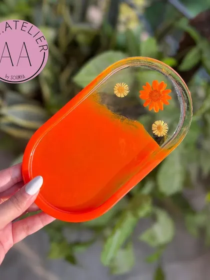 This vibrant orange oval trinket tray is perfect for adding a warm, cheerful touch to your space. The preserved flowers give it a delicate, artistic feel.