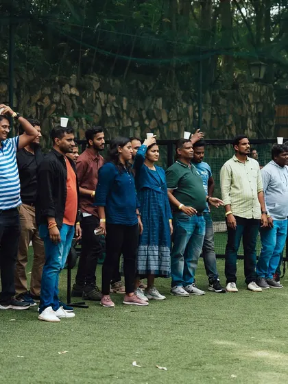 A lineup of team members, each balancing a cup on their head, ready to take on the Pyramid Builder challenge.