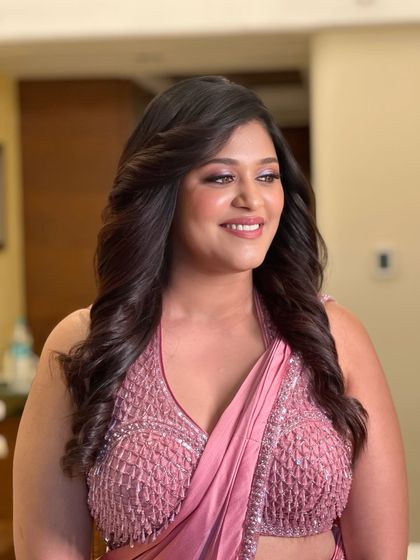 A candid shot of the bride looking radiant and happy. The glowing skin and soft curls create an effortlessly chic cocktail night look.