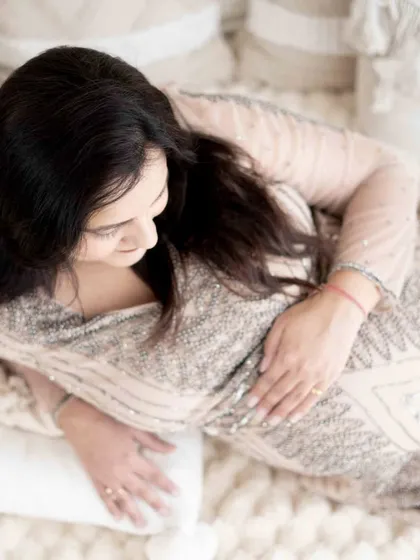 An overhead shot of a mom-to-be relaxing on our soft studio bed. This perspective creates a peaceful and intimate portrait.