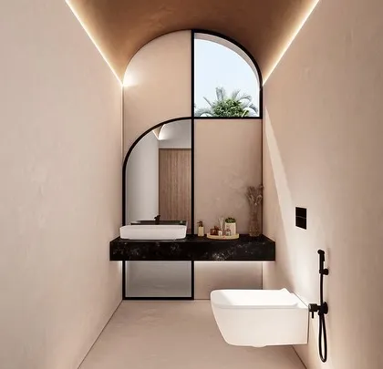 This powder room for the Vagator Villas features a unique arched mirror set against textured walls. The design plays with geometric forms and a warm, earthy palette to create a small space with a strong artistic character.