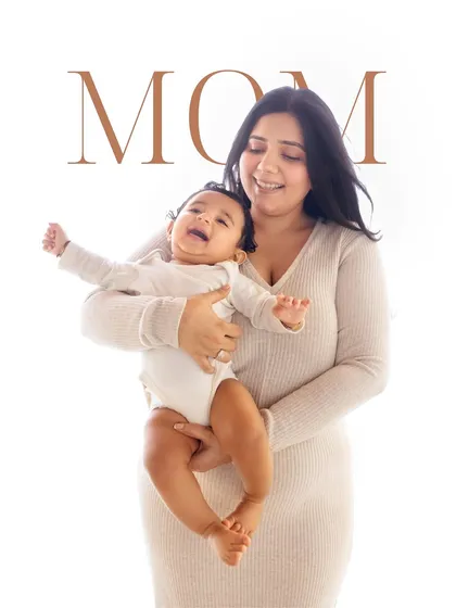A mother holds her laughing baby. My style is all about capturing the feeling of the moment, creating photos that are emotional, adorable, and minimal.