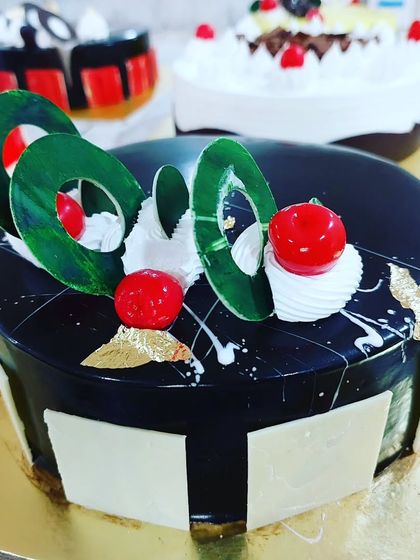 An elegant chocolate cake with a mirror glaze and artistic chocolate decorations from our professional course.