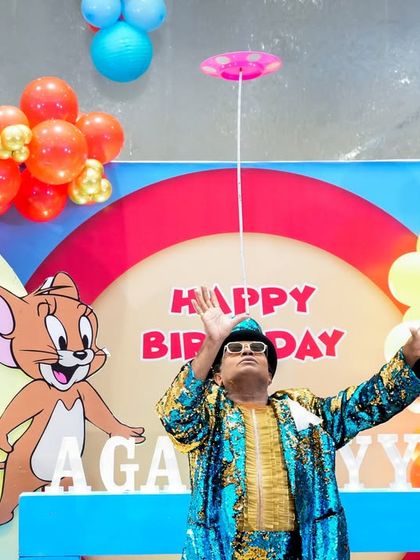 A professional entertainer wows the crowd with a plate spinning act in front of the Tom & Jerry stage.