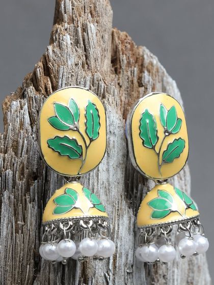 A beautiful example of our meenakari work, these jhumkas feature a yellow enamel base with hand-painted green leaves, combining traditional craft with a fresh, nature-inspired design.