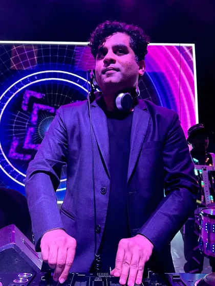 Posing for a shot before a big show. The futuristic LED background and my readiness at the console capture the excitement right before the music starts.
