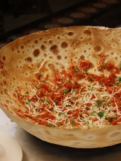 Our Crispy Masala Roomali Roti is an exotic twist on a cherished Indian bread. It's thin, crispy, and topped with a savory masala mix, making it a unique appetizer.