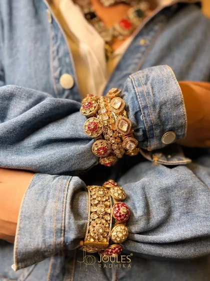 A bold fusion look. Our ornate ruby and polki kadas worn over the cuffs of a denim jacket, proving that heritage pieces can be styled in modern ways.