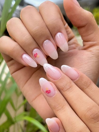 Adding a touch of whimsy to this dip powder manicure. This set features a sheer, milky base with delicate, hand-painted mushroom art for a cute and trendy look.