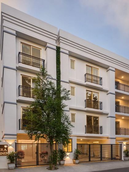 A frontal view of Panthera Westwind, showcasing the symmetrical design, classic balcony railings, and thoughtfully placed landscape elements.