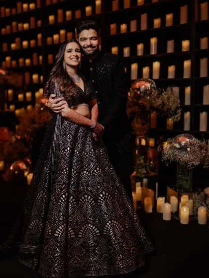 Atmosphere is everything. For this sangeet, we created a breathtaking photo backdrop with a floor-to-ceiling wall of hundreds of flickering candles, enveloping the couple in a warm, romantic glow for truly unforgettable portraits.