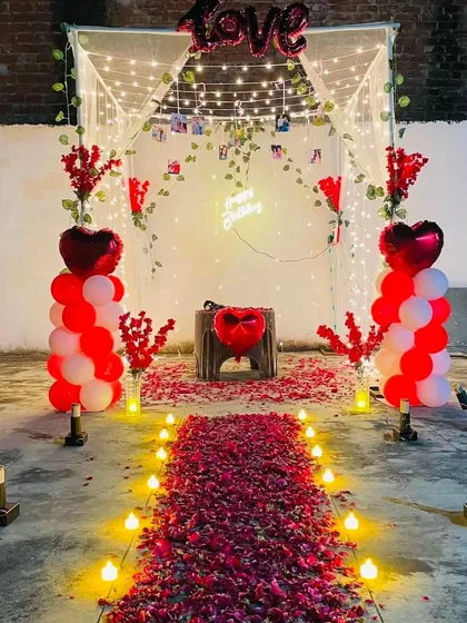 A complete romantic dinner setup on a terrace. I create a beautiful cabana with fairy lights and vines, a rose petal pathway, and balloon pillars for a magical evening.