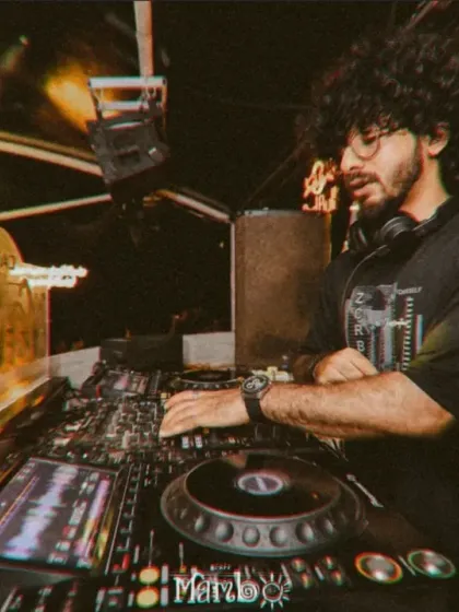 A moody, focused shot of me mixing at Cafe Mambo. The golden light from the console illuminates my workspace as I craft the sound for the night.