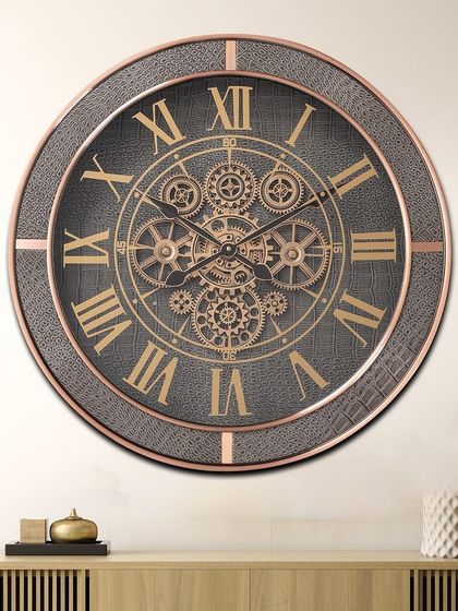 A timeless masterpiece, this large wall clock features a grey leather-textured frame with rose gold accents. The exposed moving gears and classic Roman numerals make it a luxurious and bold statement piece.