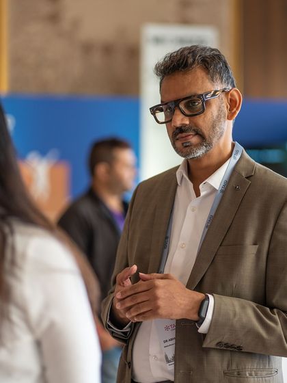 Meaningful conversations happen in the spaces between sessions. Here, I am in a one on one discussion with a conference attendee, exploring how to implement parent partnership programs effectively within school systems.