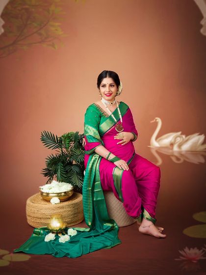 A joyful and classic portrait in a traditional 'nauvari' saree. The props and setting are designed to evoke a sense of timeless Indian heritage.