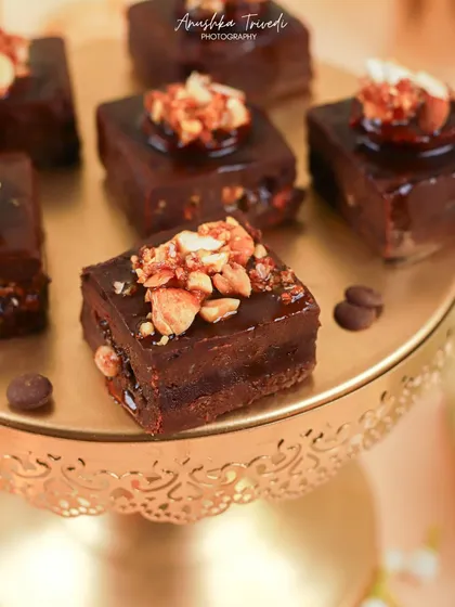 A macro shot of the festive brownies, focusing on the glossy chocolate and crunchy nut topping. This detail shot is all about making the dessert look irresistible.