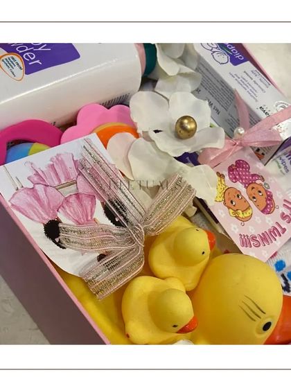 A hamper for twin girls, because miracles sometimes come in pairs. This box is filled with baby powder, rubber ducks, and other essentials for two.