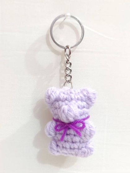 Cute and chewy-looking gummy bear keychains with little bows, available in white, brown, and lavender.