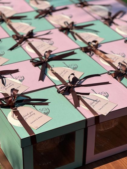 We offer a variety of packaging colors to match your event theme. Here, we used a mix of our pink and Tiffany blue boxes for a client's return favours, all tied with brown ribbons and custom "Thank you for coming" tags.