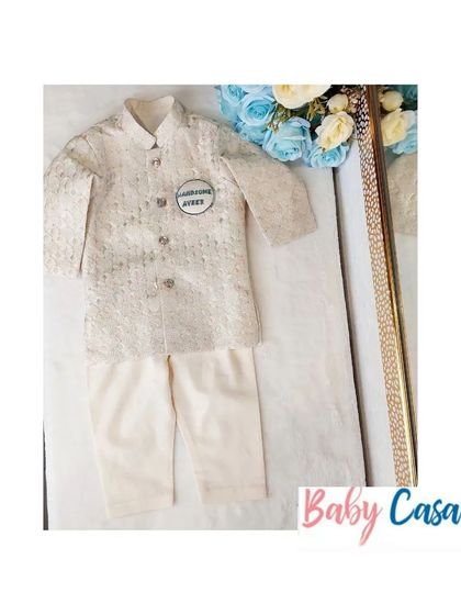 A sophisticated ethnic look for a little boy. This off-white brocade sherwani-style kurta is perfect for a wedding or a grand Diwali party.