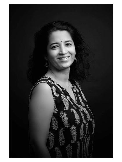 A black and white portrait with a warm, genuine smile, demonstrating the versatility of expression captured during the session.