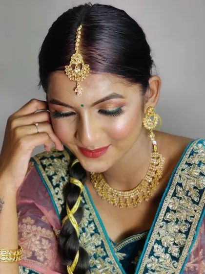A close up of the soft glam look created for brown skin. The eyeshadow has a hint of green to complement the outfit, and the skin is glowing and healthy looking.