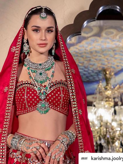 A direct, captivating shot of the bridal model. The rich red of her outfit provides a perfect contrast to the green and silver of the jewellery, making it pop.