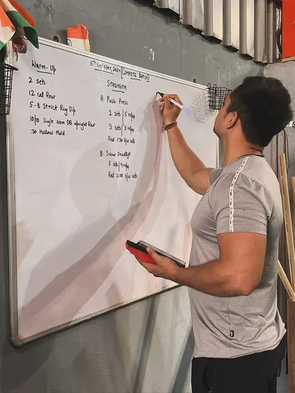 Every workout here is part of a plan. This is me mapping out a session on the whiteboard, detailing everything from the warm-up to the strength components like bench press and deadlifts. My approach to martial arts and combat fitness is structured to ensure you are always progressing safely and effectively.
