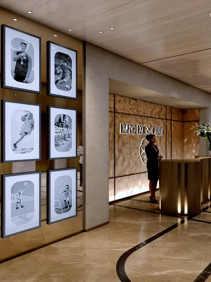 The reception area of the sports club, where a gallery wall of black and white sports photography sets the tone. The design uses warm wood and marble to create a welcoming and inspiring entrance for members.