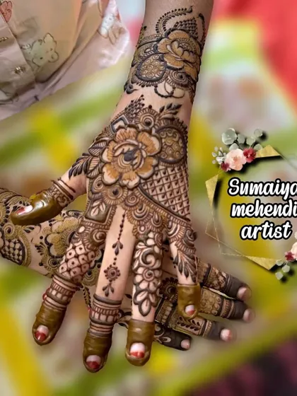 A stunning floral henna design with large, detailed flowers and intricate filler patterns.
