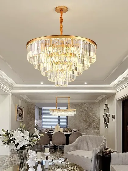 This is how we bring luxury to life. A grand, multi-tiered crystal chandelier installed in a client's living room, creating a stunning centerpiece that complements the high ceiling and elegant decor.
