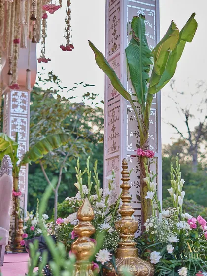 Another detail shot of the mandap, focusing on the blend of traditional brass elements, lush florals, and the modern, clean lines of the white pillars.