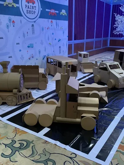 My decor is made for play. For this 'Paint Shop' party, I created a whole fleet of unpainted cardboard vehicles, including a train, bus, and truck, ready for the kids to customize. This is one of my favorite interactive activities that combines art and imaginative play.