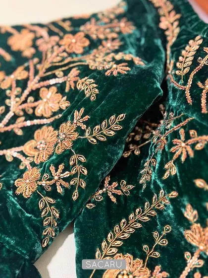 We believe in the power of details. Here, you can see the intricate gold zardosi embroidery, with delicate sequins and French knots, coming to life on a rich emerald green velvet fabric.